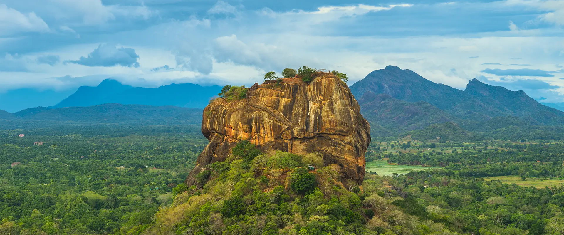 Panoramic view of the massive Sigiriya Lion Rock fortress rising above the jungle, a highlight of the Sigiriya Dambulla Day Trip from Galle.